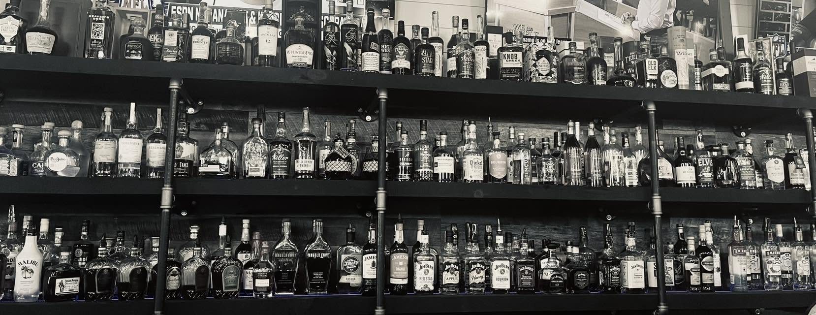 The Keg's whiskey wall — three shelves of bourbon, whiskey, tequila, rum, gin and vodka